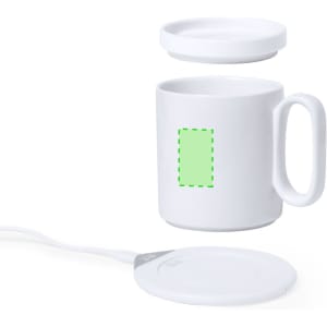 A white ceramic mug with a lid sits above a round, white wireless charger in this image.