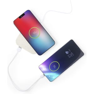 A wireless charger in white with two smartphones displaying battery percentages on top, connected by a cable.