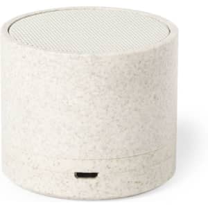 A compact, round speaker in a speckled white finish with a mesh top and a USB port. Features a logo on the base.