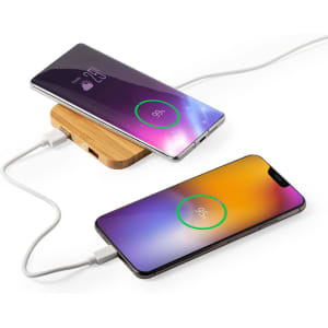 A wooden wireless charger with two smartphones displaying charging indicators in purple and orange gradients.