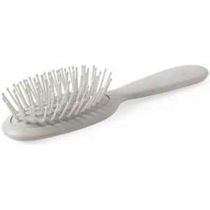 A grey hairbrush with a rounded handle and fine bristle design, featuring a logo on the side.