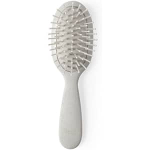 A hairbrush featuring a light grey handle and white bristles, designed for hair care. It has a branded logo.