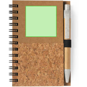 A cork and brown notebook with a green square and a pen attached, featuring a spiral binding.