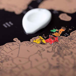 A map featuring brown and black tones, with colourful highlighted regions in red, yellow, and green. It has a logo.