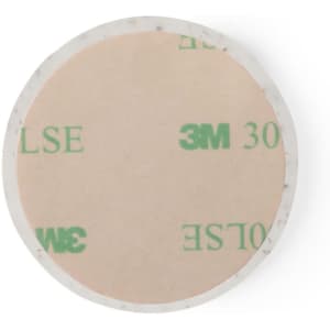 A round adhesive pad with a light beige surface and a transparent border, featuring a branding logo.