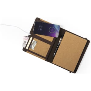 A Toskan Charger Notepad featuring a brown cork exterior, a wireless charging pad, and compartments for cards and a pen.