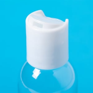 A clear hand sanitiser bottle with a white flip cap against a blue background.