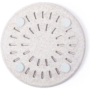 A circular wireless charger in a light beige colour with textured surface and rubber grips.
