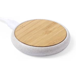 A wireless charger featuring a bamboo top and a white base, with a cable attached.