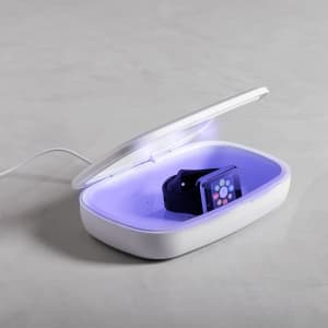 A white UV sterilizer box with a purple interior, featuring a smartwatch inside. The box is open and plugged in.