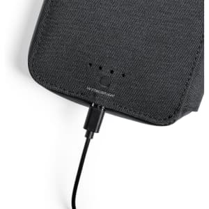 A black UV sterilizer organizer with a textured surface and a charging cable connected.