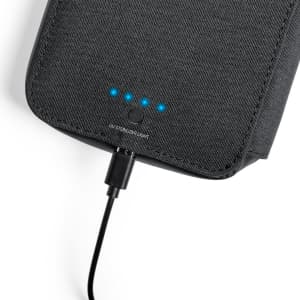A black UV sterilizer organizer with indicator lights and a charging cable connected.