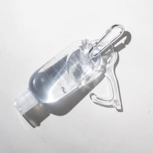 A clear antibacterial gel bottle with a carabiner attached, designed for convenience and portability.