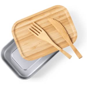 A metal lunch box in silver, topped with a bamboo lid and wooden utensils, including a fork and knife.