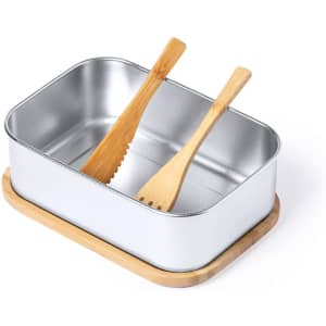 A silver lunch box with a bamboo base and two wooden utensils inside. It has a sleek, modern design.