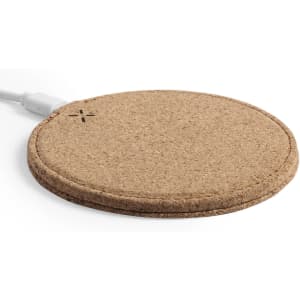 A wireless charger featuring a round, natural cork design with a white charging cable.