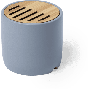 A round speaker in light blue with a wooden top featuring slits for sound output. It has a minimalistic design and a logo.