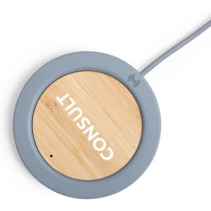 A wireless charger with a round grey base and a bamboo top, featuring a logo.