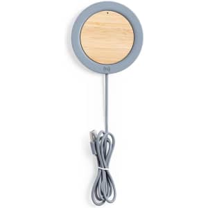 A wireless charger with a round design featuring a bamboo centre and a grey exterior, accompanied by a USB cable.