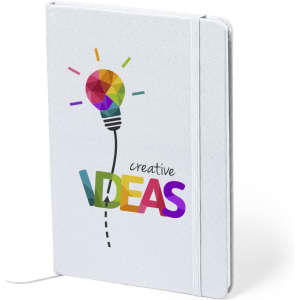 A white notepad featuring a colourful light bulb design with the text "creative IDEAS" and an elastic band.