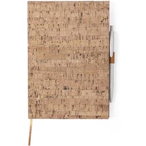 A cork-textured notepad featuring a pencil attached and a unique natural finish, with a ribbon bookmark.