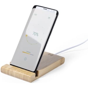 A wireless charger with a wooden base and a smartphone displayed upright, indicating charging progress.