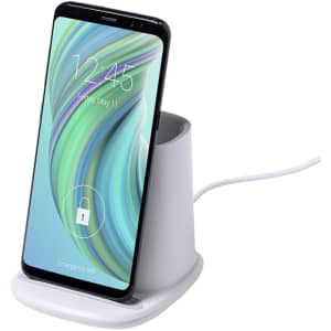 A white multifunction pencil holder with a smartphone docked, featuring a wireless charging pad.