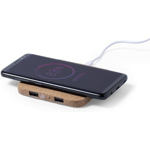 A wireless charger in a natural cork design, with a smartphone charging on top and USB ports visible.