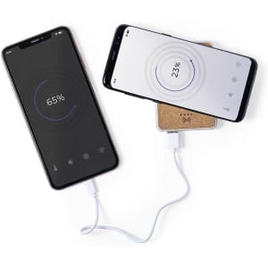 A power bank charging two smartphones, one in black and one in white, connected with a white cable.