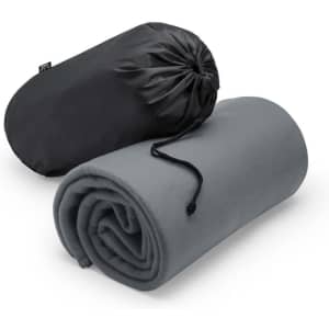 A rolled grey blanket with a black carrying pouch, featuring a drawstring closure and branding.