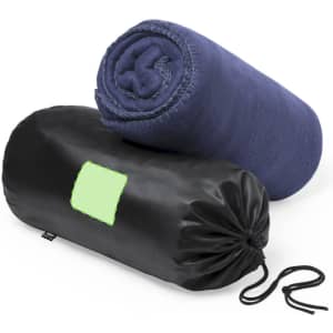 A rolled navy blanket positioned on top of a black carrying pouch, featuring a logo.