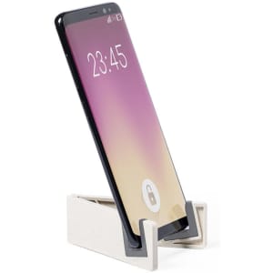 A phone stand in light grey with a black support, holding a smartphone at an angle.