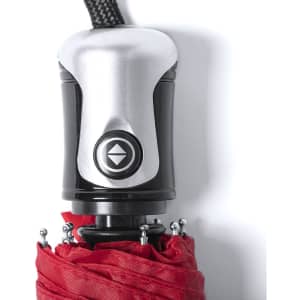 A close-up of a red umbrella handle featuring a silver mechanism and a black strap.