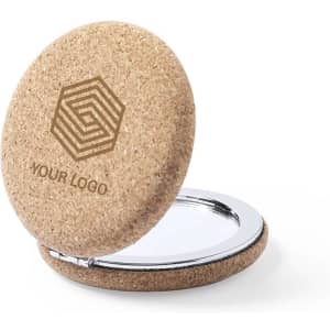 A round cork pocket mirror with a shiny silver interior and a logo on the outer surface.