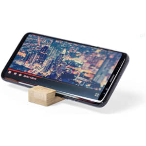 A phone holder made of wood, supporting a smartphone displaying a cityscape video in vibrant colours.
