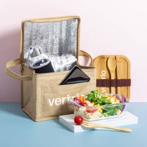 A beige lunch box with a silver interior, holding a drink bottle, a phone, and a bamboo cutlery set.