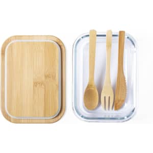 A bamboo lunch box with a clear base and two bamboo utensils: a spoon and a fork. Branding is visible.