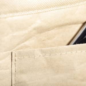 A beige cooler bag with a visible pocket and a drink bottle or phone partially inserted. Features stitching details.