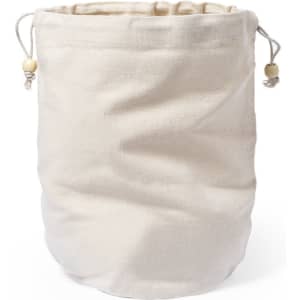 A cream toiletry bag made of fabric, featuring a drawstring closure and wooden beads. It has a simple design.