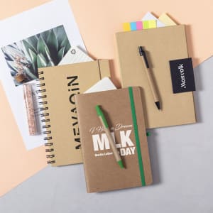 A collection of notebooks in various sizes and styles, featuring natural brown covers and a green pen.