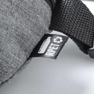 A grey waistbag featuring a textured fabric and a black label indicating recycled materials.