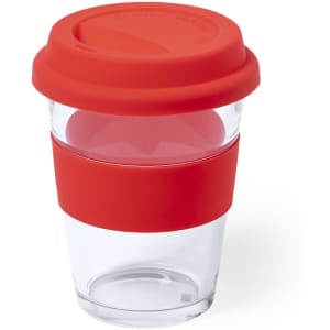 A reusable coffee mug in clear glass with a red silicone lid and band, featuring a modern design.