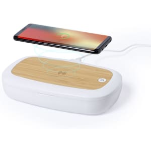 A wireless charger with a bamboo top and white base, and a smartphone placed on top for charging.