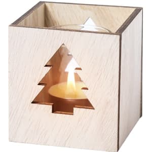 A square wooden candle holder with a Christmas tree cutout, featuring a lit candle inside.