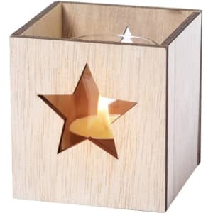 A wooden candle holder with a star cut-out design, featuring a lit candle inside. The wood is a light, natural tone.