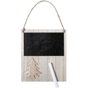 A decorative wooden chalkboard with a Christmas tree design and a twine hanger, featuring a white chalk stick.