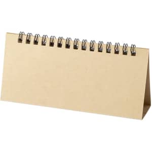 A desktop calendar with a spiral binding and a beige cover, featuring a simple, minimalistic design.