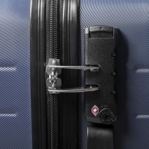 A close-up of a navy wheeled bag featuring a sturdy zip and a lock mechanism. It has a logo on the side.