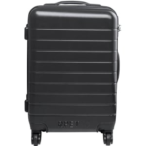 A black wheeled bag with a ridged design and a logo, featuring a sturdy handle and four wheels for easy transport.