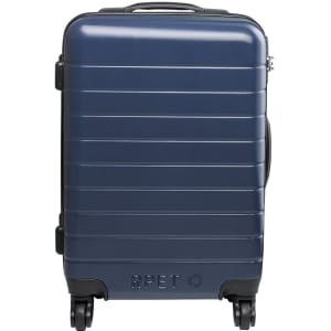 A navy wheeled bag with a sleek, ribbed design and a logo, featuring a sturdy handle and four wheels.